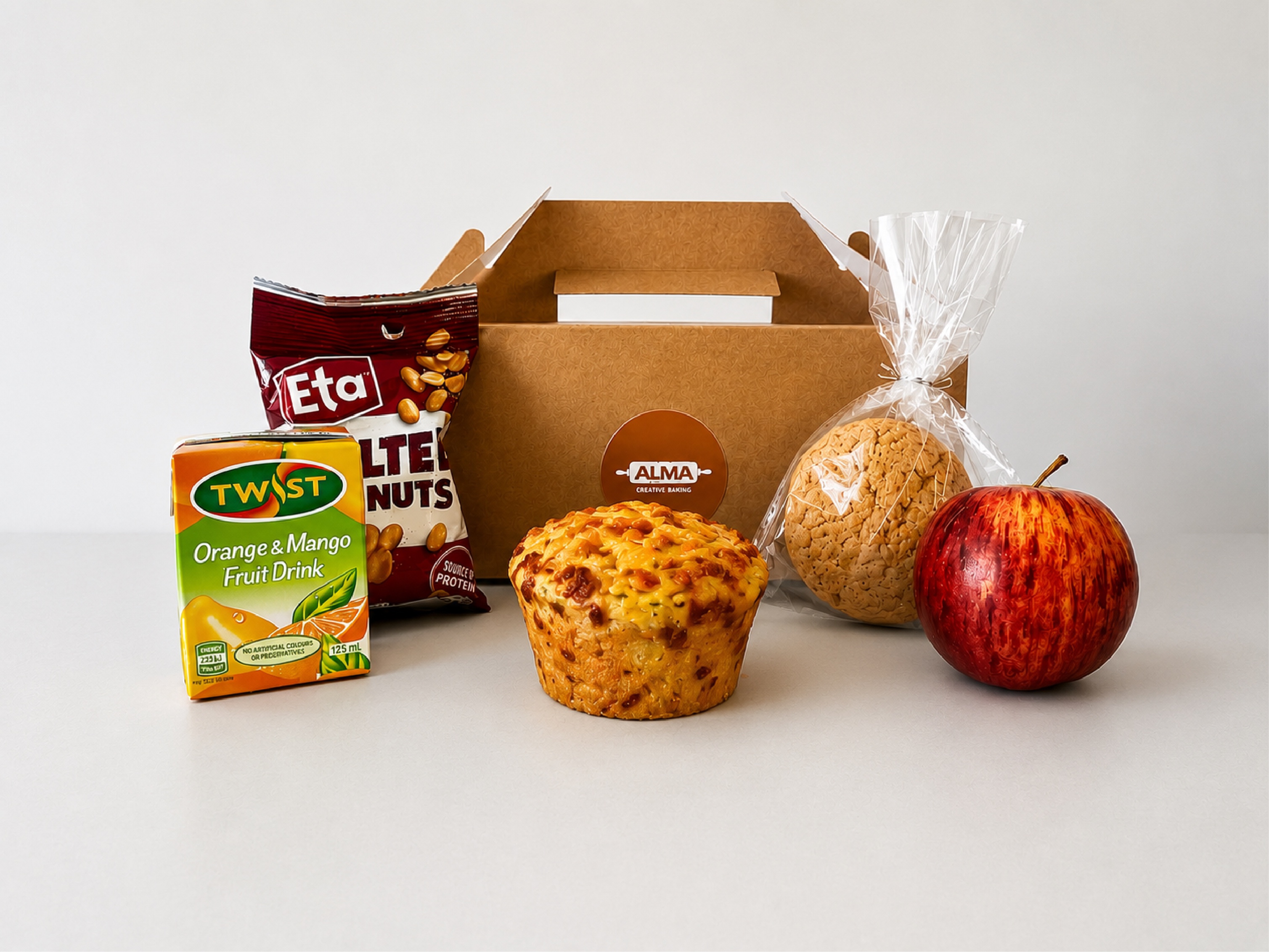 A real Alma care box with a handmade savoury muffin, biscuit, fruit, nuts and a drink